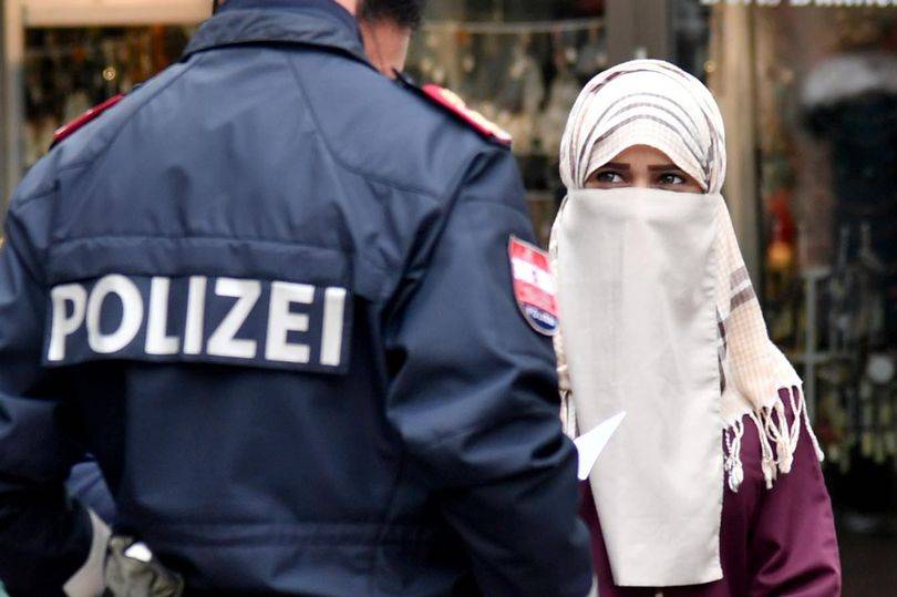 بالصور - شرطي يُجبر شابة مسلمة على خلع نقابها في الشارع