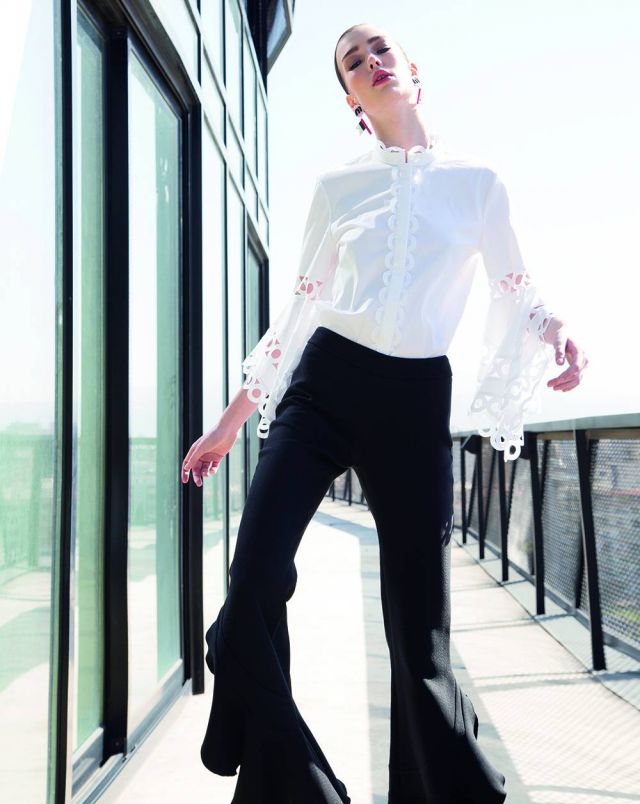 سروال أسود من Giambattista Valli. قميص أبيض من Oscar de la Renta. أقراط للأذنين من MiuMiu.