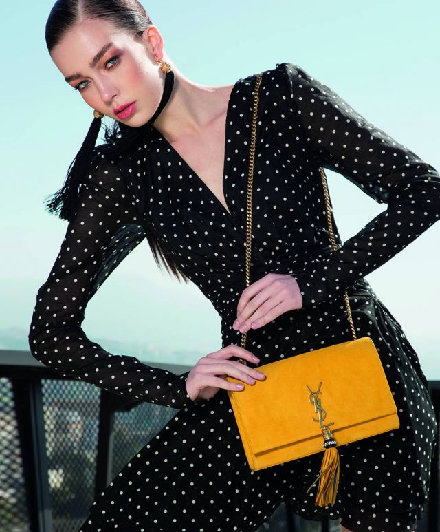 فستان من القطن المطبع بالنقاط من Alexandre Vauthier. حقيبة وأقراط للأذنين من Saint Laurent.