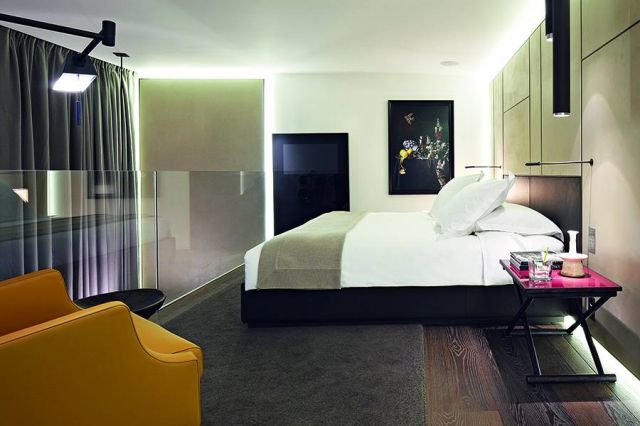 غرفة نوم بأرضية خشبية داكنة وألوان متناقضة متناغمة