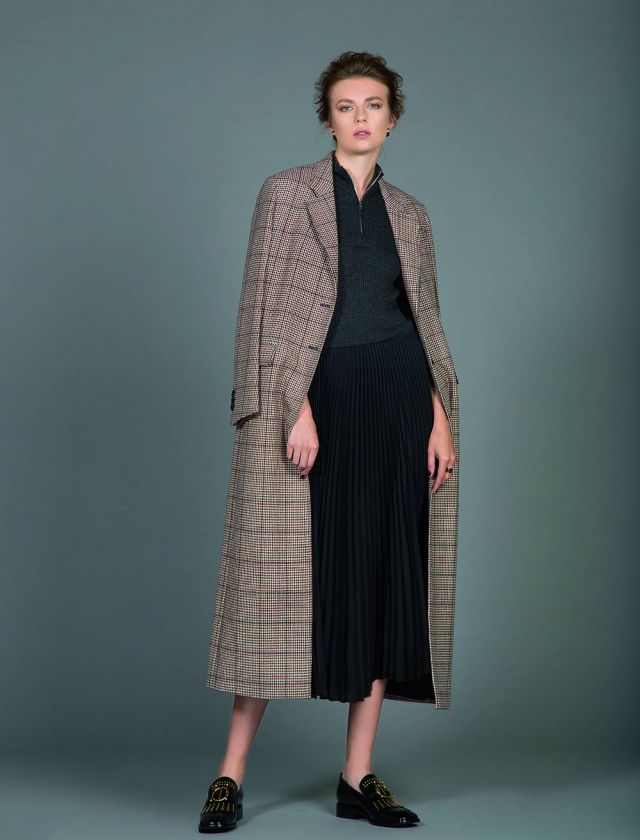 فستان من النسيج المحبوك ومعطف طويل مطبع بالمربعات من Prada. حذاء من Dior.