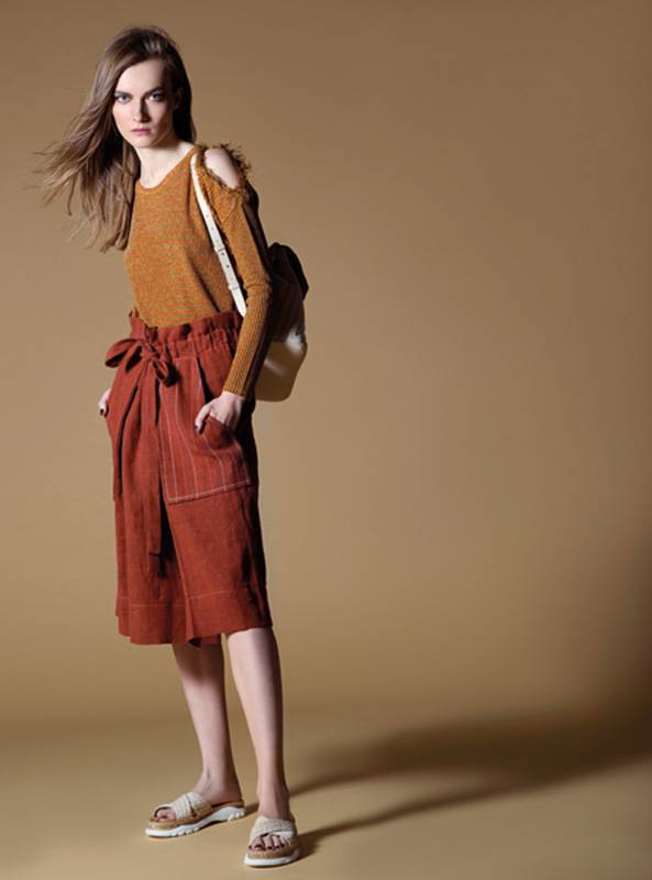 برمودا من الكتان وتوب من نسيج اللوريكس من Sonia Rykiel. حقيبة للظهر من Chloe. حذاء من Stella McCartney.