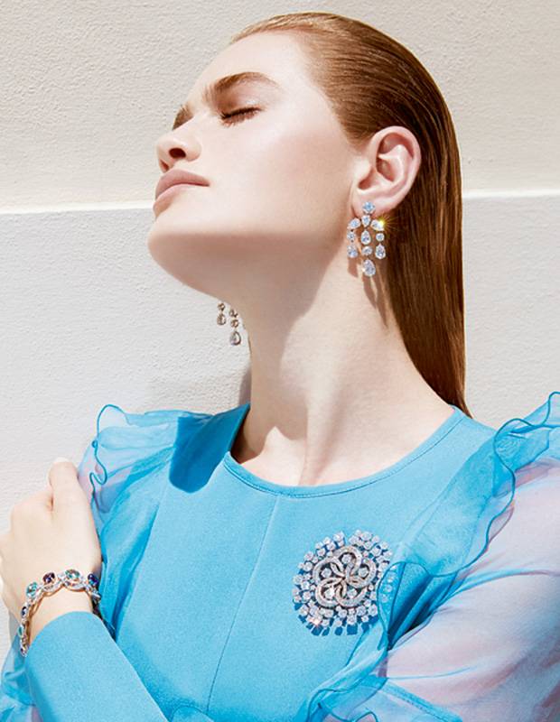 أقراط للأذنين ومشبك BVLGARI High Jewellery من البلاتين والماس • سوار BVLGARI High Jewellery من الذهب الأبيض والأكوامارين، والتنزانيت، وحجر القمر والماس • توب باللون الأزرق الشاحب من Andrew GN   