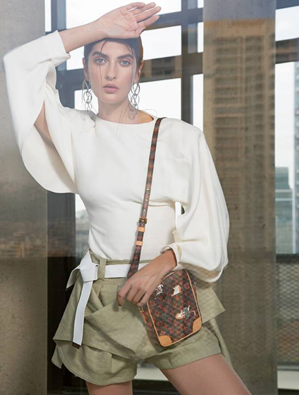 بلوزة أنيقة وشورت مزين على الجانبين، مع حقيبة Paname، وأقراط الأذنين INFINIVY 3 MAILLONS.