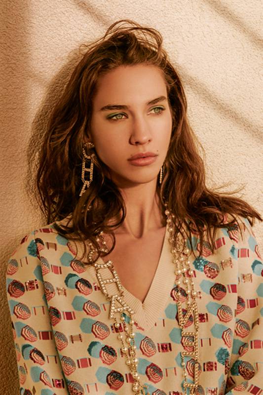 بلوزة من القطن والحرير بألوان العاج والأزرق والوردي مزيّنة بالبرق اللمّاع أقراط للأذنين من  المعدن والنحاس عقد متعدد الطبقات من المعدن والخرز الزجاجي والنحاس