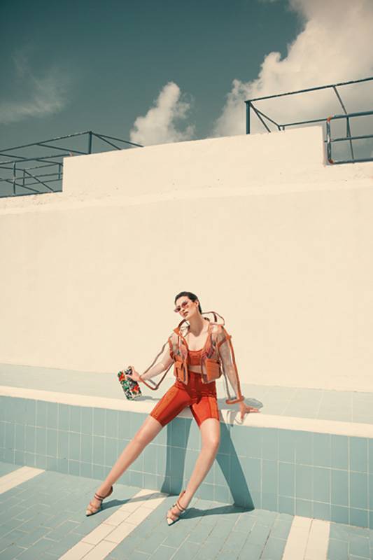 توب وشورت ضيّق مطبعان بشعار الدار  F motif fitted cropped top & biker short جاكيت من PVC. نظارات شمسية Defender Sunglasses. الكل من فندي FENDI.