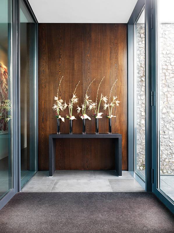المدخل يلبس حلّة أنيقة، يزيّنه كونسول من الخشب، مُنسَّق بأوانٍ من الأزهار