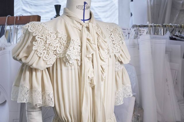 زركشة الدانتيل من الأزهار عبر الأكمام المتماوجة