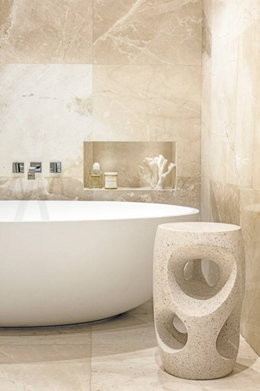 جانب من البانيو في صالة الحمّام تزيّنه طاولة من «أولي ستديو»