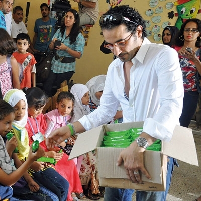 أحمد حلمي يوزع حقائب الطعام على التلاميذ