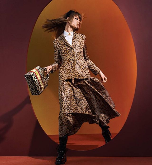 سترة Bar  بنقشة ميزا Mizza  قميص أبيض تنورة Mizza Bar  باللون البيج  جزمة D-fight Boots سوداء حقيبة Lady D-lite بنقشة ميزا Mizza  أقراط للأذنين عقد  خواتم