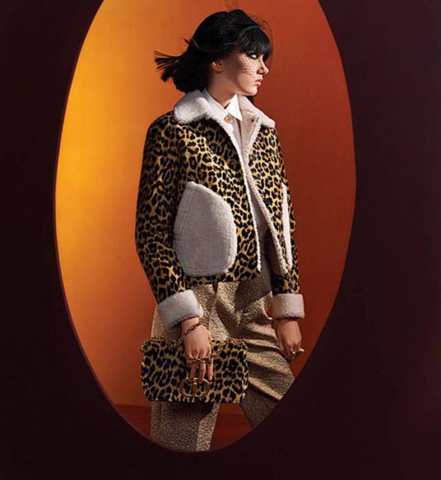 عصبة سوداء للرأس سترة Mizza  باللون البيج المرقط بنقوش النمر قميص أبيض سروال ذهبي عقد خواتم حقيبة Dior Caro بنقشة ميزا Mizza 