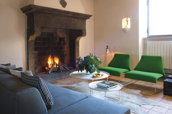 الصالون ويحتل جانبا منه مدفأة قديمة عملاقة وقد نسقت حولها جلسات مريحة ناعمة