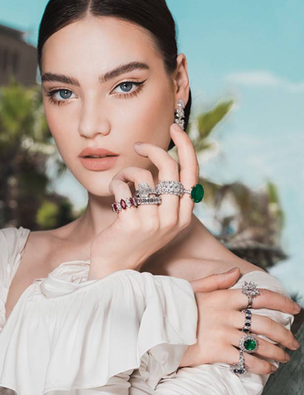 الفستان من ساندرا منصورSandra Mansour والمجوهرات هي خواتم ومحابس  زواج وخواتم خطوبة  من الياقوت والسفير والزمرد والماس من  جورج حكيم  George Hakim.