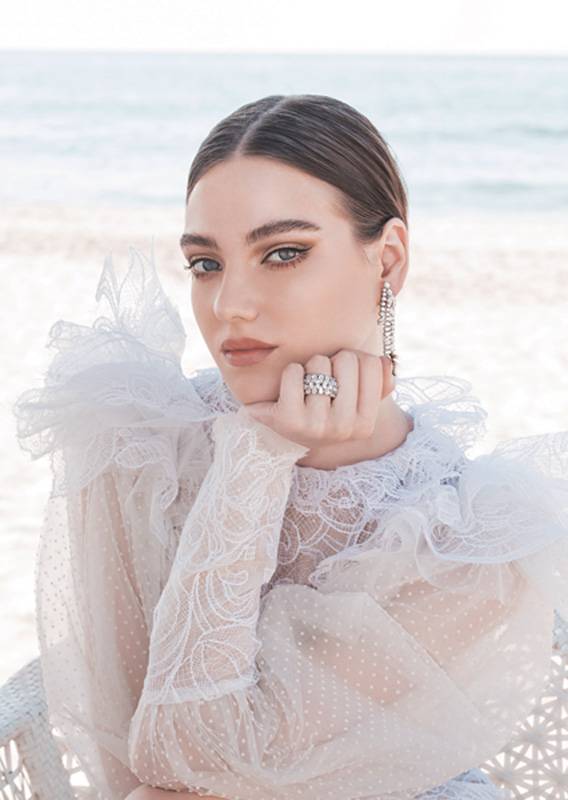 الفستان من كارولين لانغ Karoline Lang والمجوهرات هي أقراط متدلية للأذنين  مع محبس زواج متناسق من الماس من جورج حكيم George Hakim.