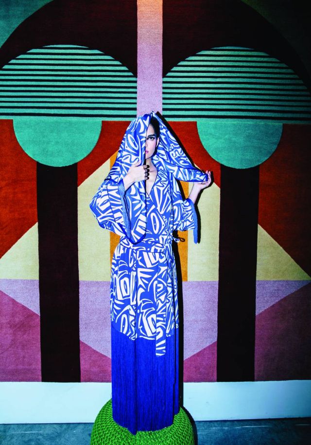 إطلالة كاملة من Marina Rinaldi  سجادة Chipo and Zo من تصميم Zaven محبوكة يدوياً في النيبال باستعمال صوف الهيمالايا متوافرة لدى محلات إيوان مكتبي  (دبي وبيروت)