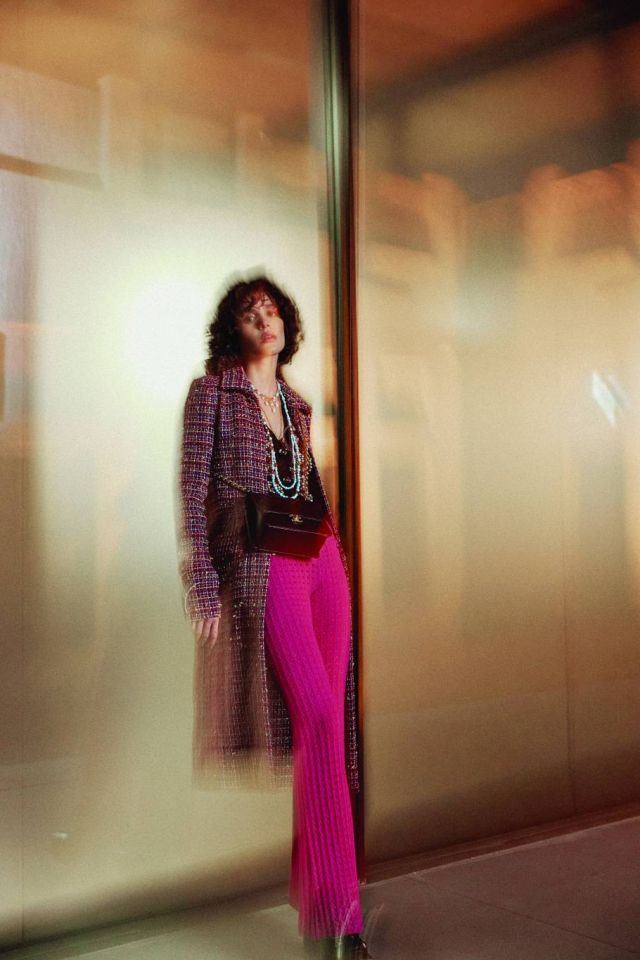 معطف من تويد القطن الوردي والأسود والفيروزي والأصفر. كنزة من الصوف والقطن البرغندي، والأسود، والوردي والبرتقالي مزينة بالخرز. سروال من الصوف الفوشيا. عقود من المعدن والخرز الزجاجي والستراس. عقد من المعدن والراتنج والستراس. حزام من المعدن والخرز الزجاجي والستراس. حقيبة من الجلد البرغندي اللماع والمعدن. صندل من الجلد والجلد اللماع بلونيّ . البرغندي والأسود. الكل من شانيل CHANEL