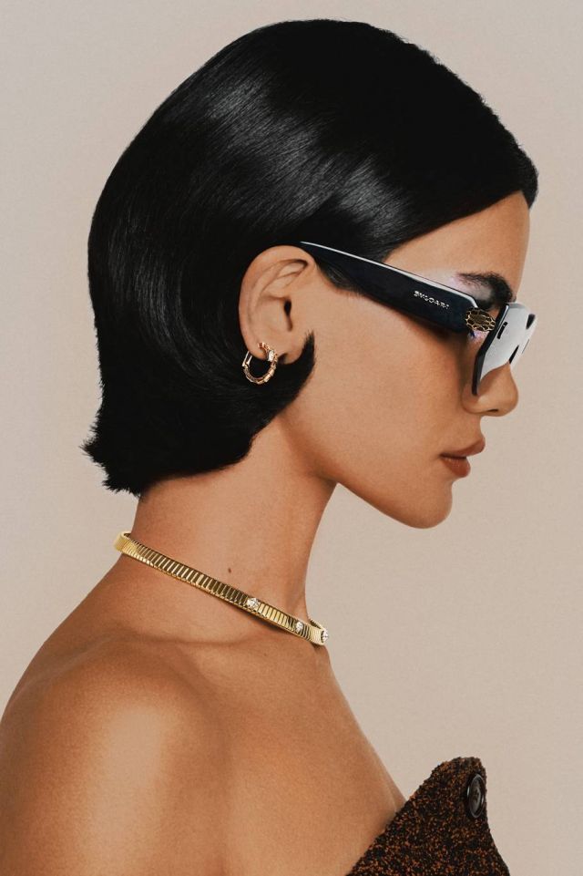 نظارات شمسية Serpenti Forever بدون إطار مع زينة رأس ثعبان مطلية بالمينا من Bvlgari.
 أقراط Serpenti Viper من الذهب الأصفر والماس وعقد Tubogas من الذهب الأصفر من Bvlgari.
بلوزة من Del Core.