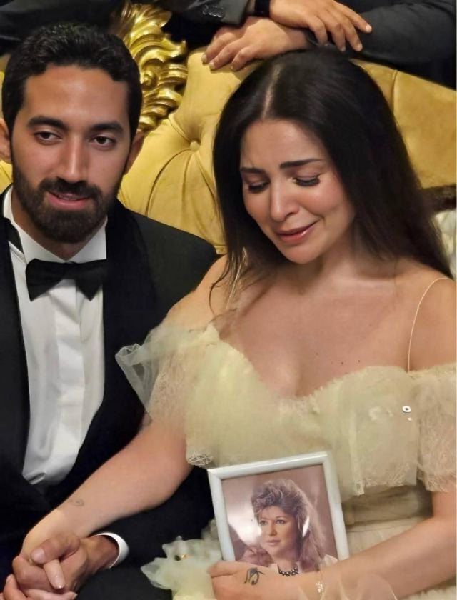 مي عز الدين تبكي ممسكةً بصورة والدتها