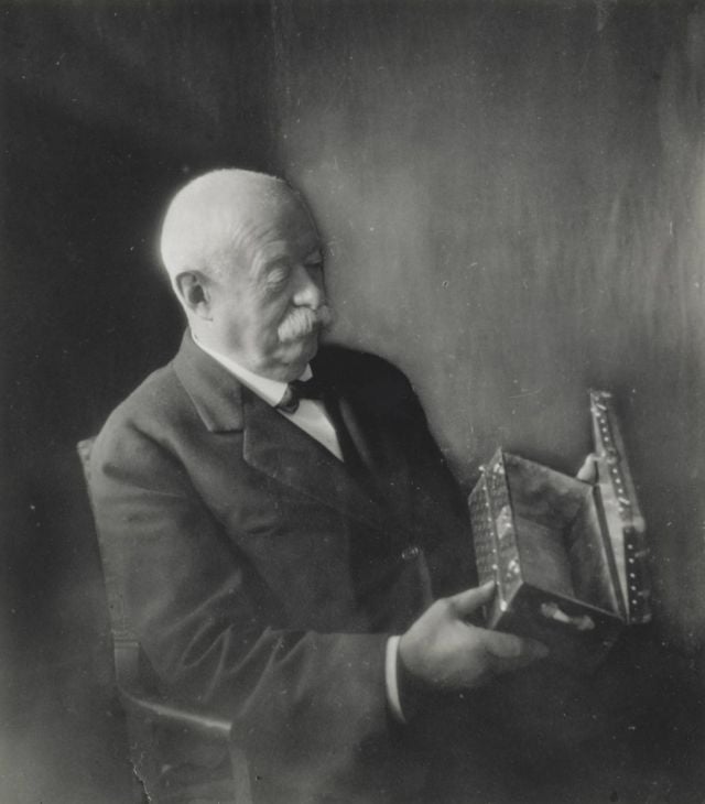 Georges Vuitton examining a Malle Fleurs in Monogram canvas, circa 1930 (gelatin silver print)- This miniature trunk, fitted with a zinc tray