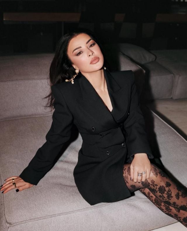 ماغي بو غصن تنسّق الجوارب الموردة مع فستان البليزر