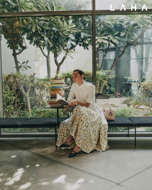 أقراط، فستان قميص طويل أبيض مزين بالزهور، حقيبة “Lady Dior” باللون الوردي مع فيونكة وحذاء “Dior Muse” باللونين الأسود والأبيض من Dior 