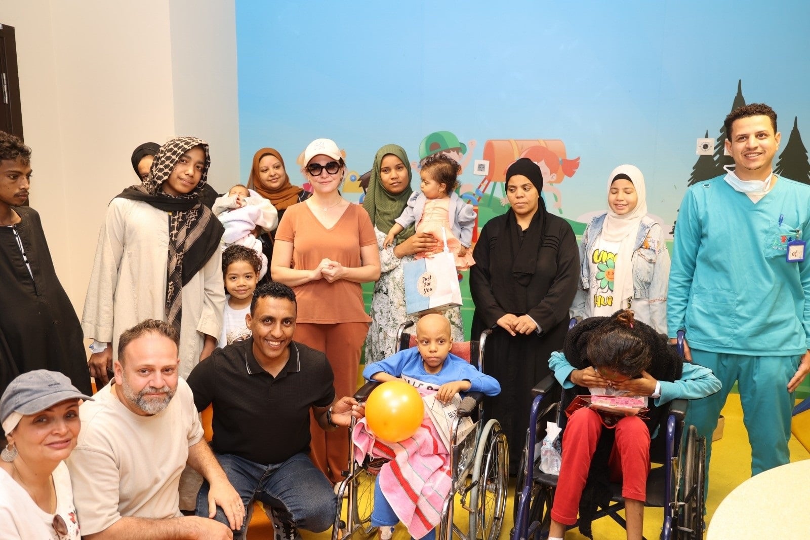 ريهام عبد الغفور في لقطة تذكارية مع الأطفال وفريق عمل المستشفى