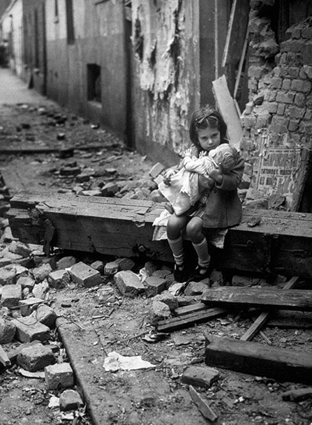 17-Little girl with her doll sitting in the ruins of her bombed home London 1940