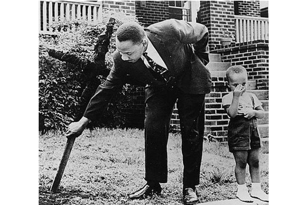 24-Martin Luther King with his son removing a burnt cross from their front yard 1960