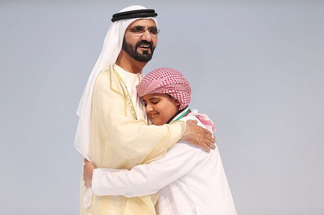 الشيخ محمد بن راشد محتضناً الطفل أديب البلوشي