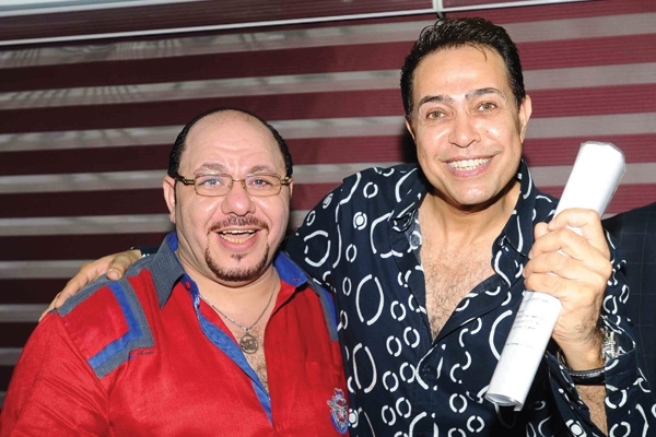 حكيم يحمل عقد برنامجه بين يديه