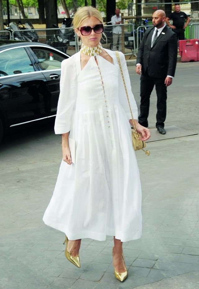 لورا بايلي في إطلالة بغاية «الشياكة» بفستان باللون الأبيض مع لمسة توهّج بالأكسسوارات وحقيبة شانيل الذهبية.