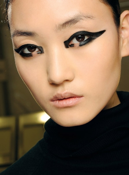 في عرض Monique Lhuillier - Val Garland: الماكياج أنيق وحادّ، من الثلاثينات. البشرة على طبيعتها، والشفاه طبيعيّة، والتركيز على العيون.