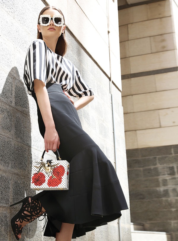 تنورة طويلة، وتوب من الحرير المخطط، ونظارات شمسية وحقيبة. الكل من Dolce&Gabbana.
