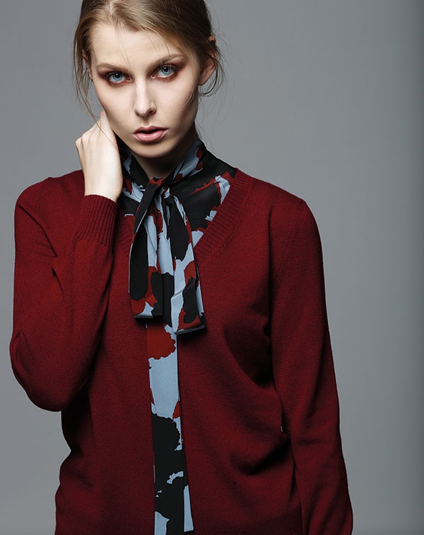 بلوزة من الحرير المطبع وكنزة باللون الأحمر الداكن من Gucci.
