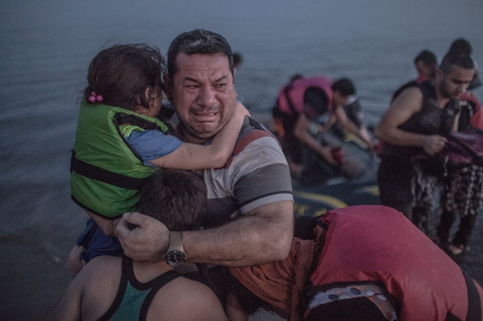 القصة وراء صورة اللاجئ الذي يحتضن طفليه باكياً