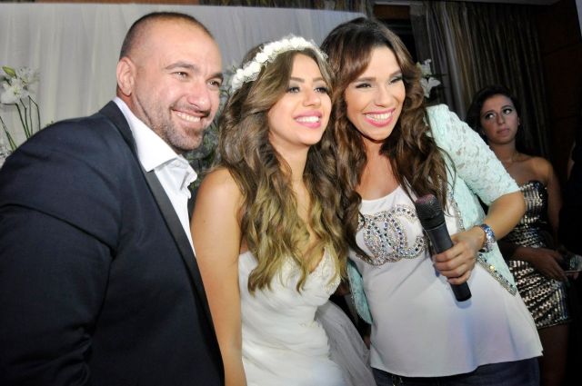 أمينة تظهر عليها علامات الحمل مع العروسين