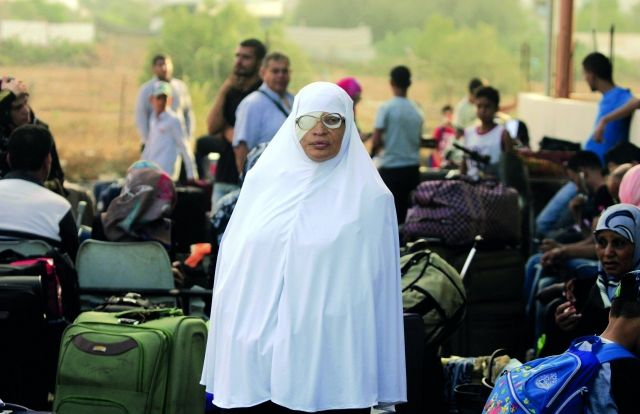 امرأة مسنّة تنتظر إذن الدخول إلى مصر من معبر رفح بين فلسطين ومصر عند حدود قطاع غزة. وقد سمحت مصر للفلسطينيين بالعبور لمدة 4 أيام لأول مرة منذ شهرين.