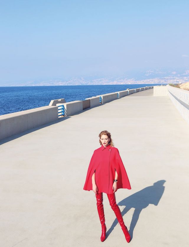 رداء أحمر وأقراط للأذنين من Versace. جزمة عالية جداً من Stuart Weizman.
