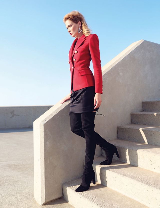 تنورة من ساتين الحرير الأسود وسترة من الكريب الأحمر من Balmain. جزمة عالية جداً من Stuart Weizman.
