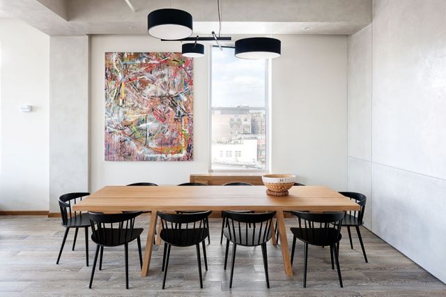 صالة الطعام تتوسطها طاولة من خشب السّنديان الخالص، تحيط بها كراسٍ مُبتكرة من الخشب المطليّ باللون الأسود