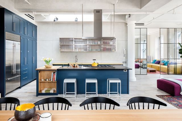 مشهد عام من ركن صالة الجلوس وغرفة الطعام والمطبخ يفيض بالأناقة والألوان المتناغمة