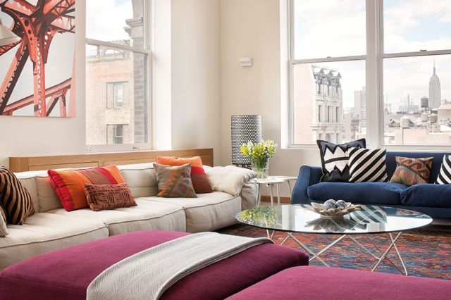 ركن من الصالون تزيّنه جلسات مريحة بألوان باردة ودافئة