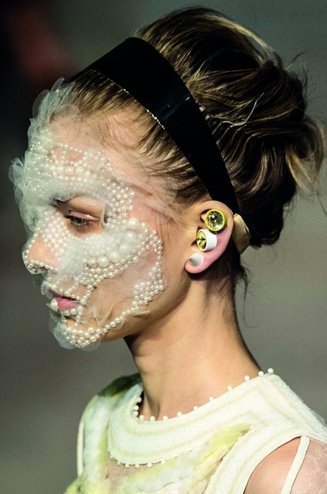 عارضة ترصّع اللآلئ وجهها بنعومة وتبرز الأقراط الحادة في أذنها في عرض Givenchy. عارضة ترصّع اللآلئ وجهها بنعومة وتبرز الأقراط الحادة في أذنها في عرض Givenchy.