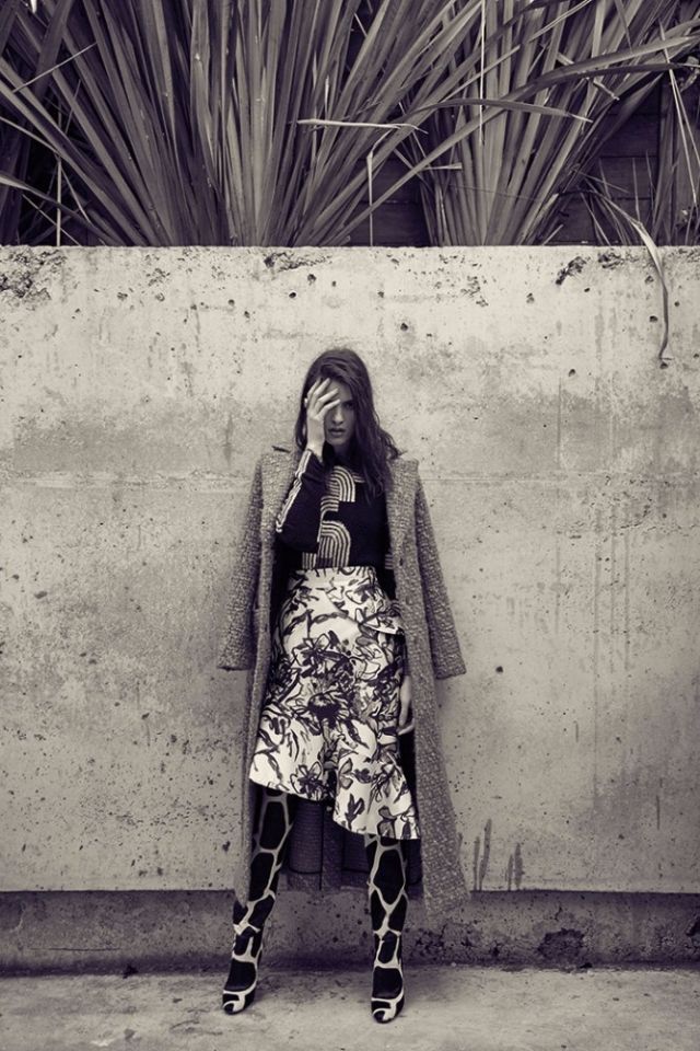 كنزة سوداء مطبعة من Peter Pilotto لدى Harvey Nichols. تنورة من الساتين المطبع من Oscar de la Renta لدى Selfridges. معطف من Dior. جزمة من Sergio Rossi.
