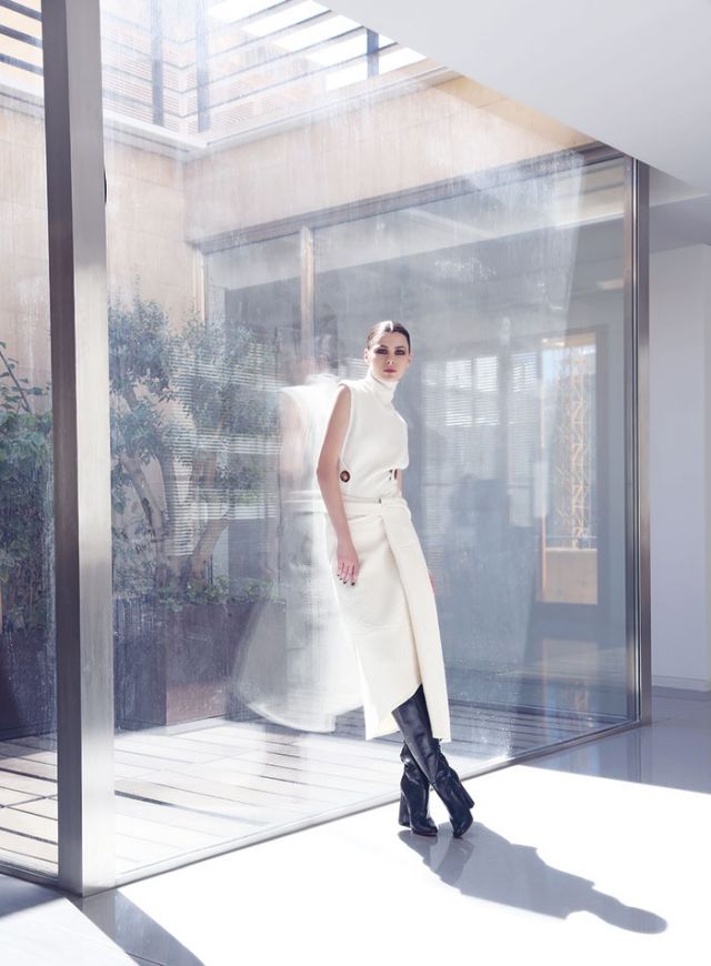 توب وتنورة من الصوف الأبيض من Victoria Beckham. جزمة من الجلد من Santoni.
