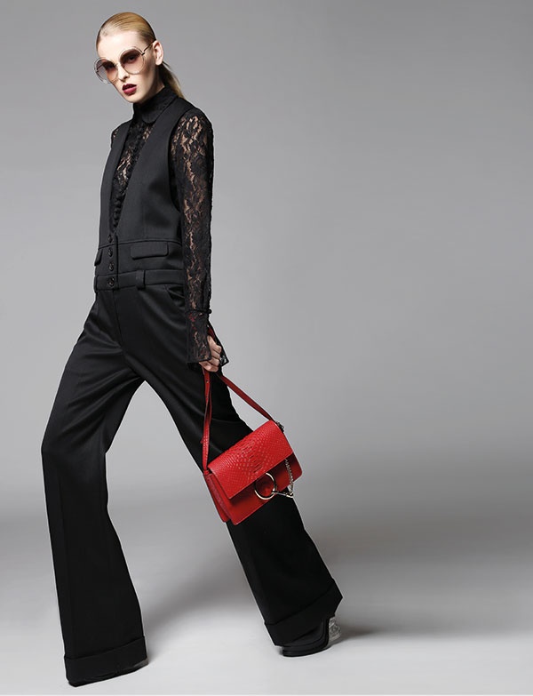 قميص من الدانتيل الأسود وبذلة ذات قطعة واحدة من الكريب الأسود. حقيبة من الجلد الأحمر ونظارات شمسية.
 الكل من Chloe.
