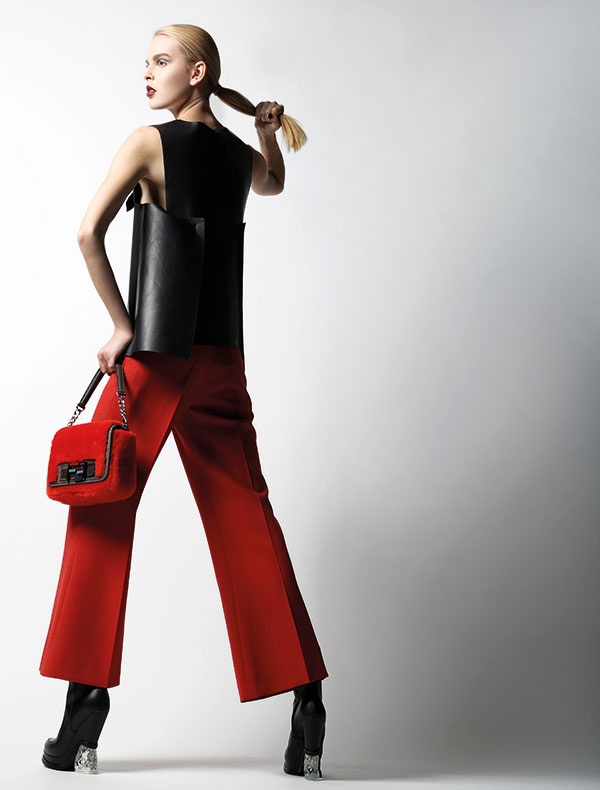توب من الجلد الأسود مع سروال أحمر. حقيبة من الفرو الأحمر وجزمة. 
الكل من Fendi.
