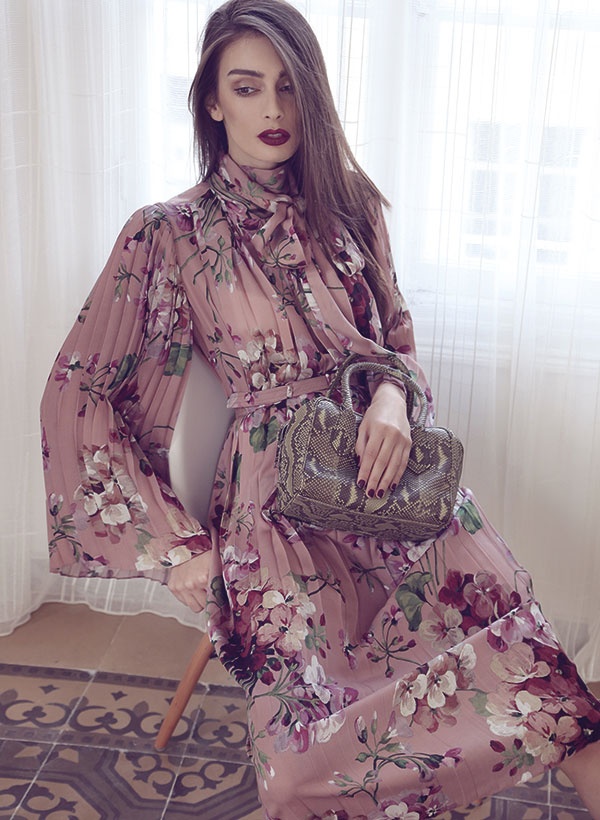 فستان من موصلين الحرير المطبع بالأزهار من Gucci. حقيبة  من جلد الثعبان من Prada.
