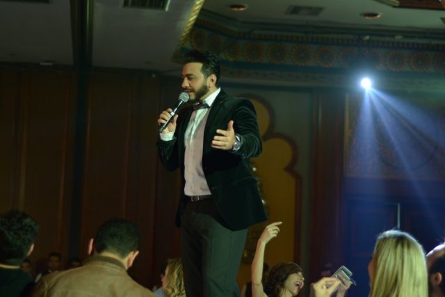 بالصور - زوجة تامر حسني تسانده.. وهكذا استقبله الجمهور على رأس السنة